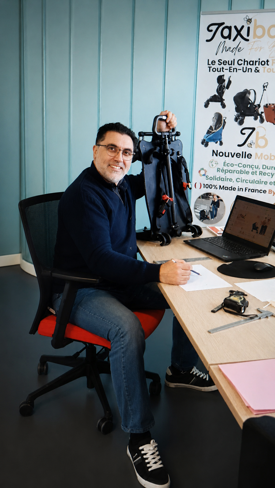 Kamel, fondateur de TaxiBabee, avec le chariot plié dans son bureau